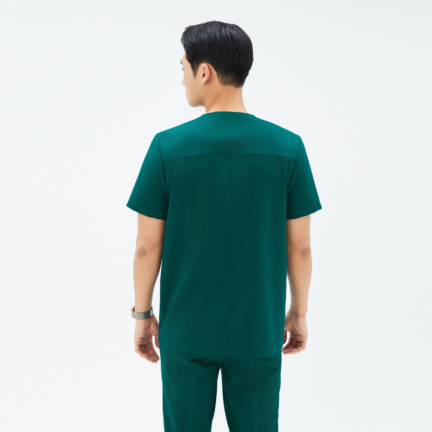 Image of Back view of TUL DS-191 Men's Pine Green scrub top, emphasizing structured seams and a comfortable short-sleeve design.