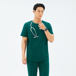 Image of Model adjusting stethoscope while wearing TUL DS-191 Men's Round Snap Zipper Scrub Top in Pine Green, featuring front pockets and short sleeves.