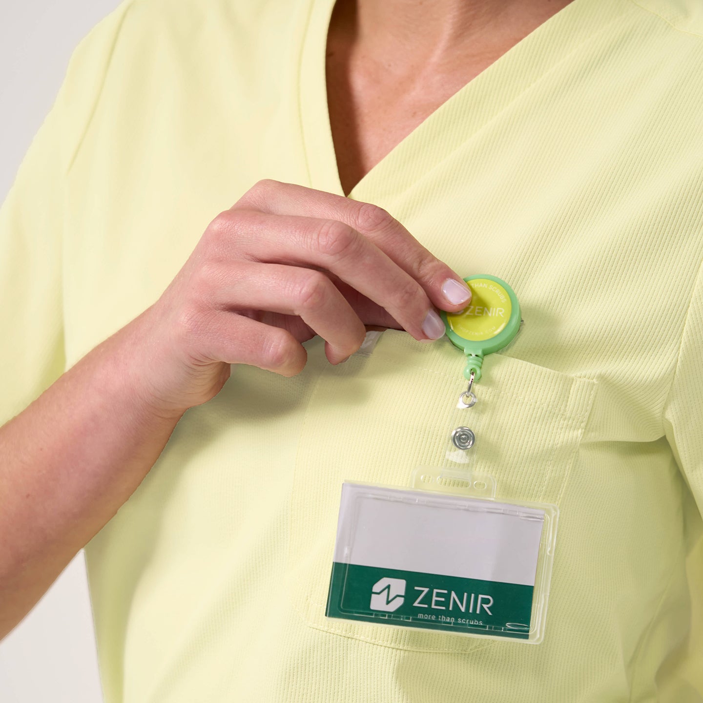 Image of Chest pocket detail on the Women's Pineapple Yellow Single Pocket Scrub Top with ID badge attachment, close-up shot