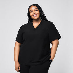 Image of Smiling plus size model wearing the black scrub top, featuring a V-neck, short sleeves, and a relaxed fit against a neutral background,Rich Black