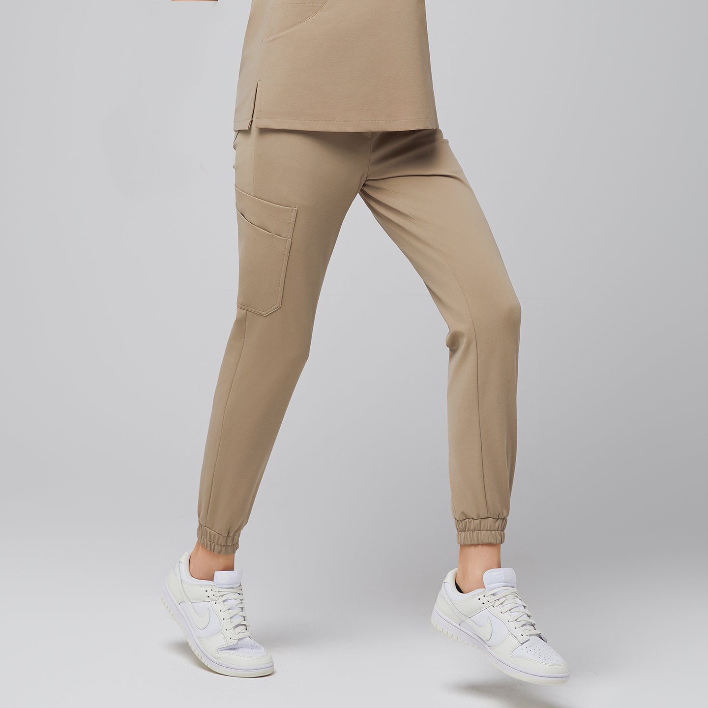 Image of Sand Beige StretchFit Jogger Scrub Pants made with flexible stretch fabric, featuring tapered legs, elastic cuffs, and side cargo pocket for everyday comfort.