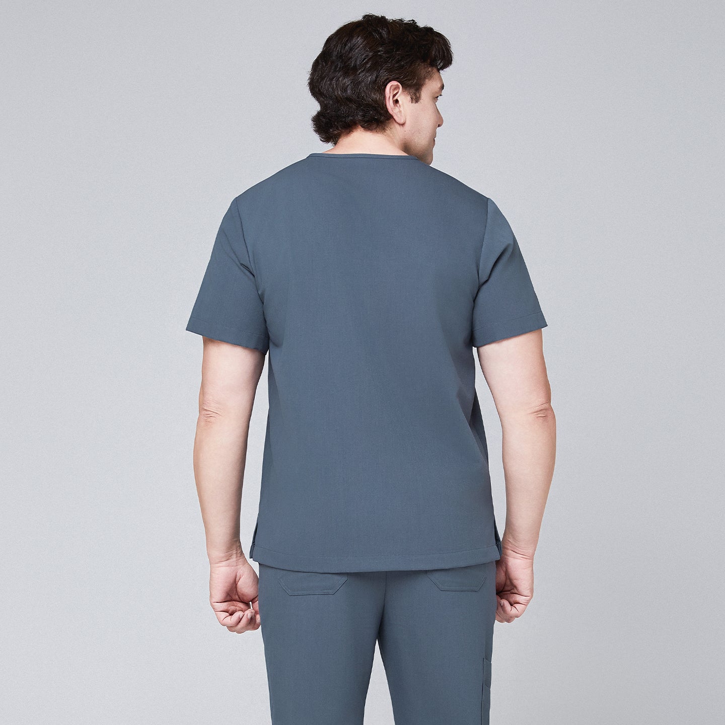 Image of Back view of a man wearing a smoky blue scrub set with a clean, minimalist design,Smoky Blue