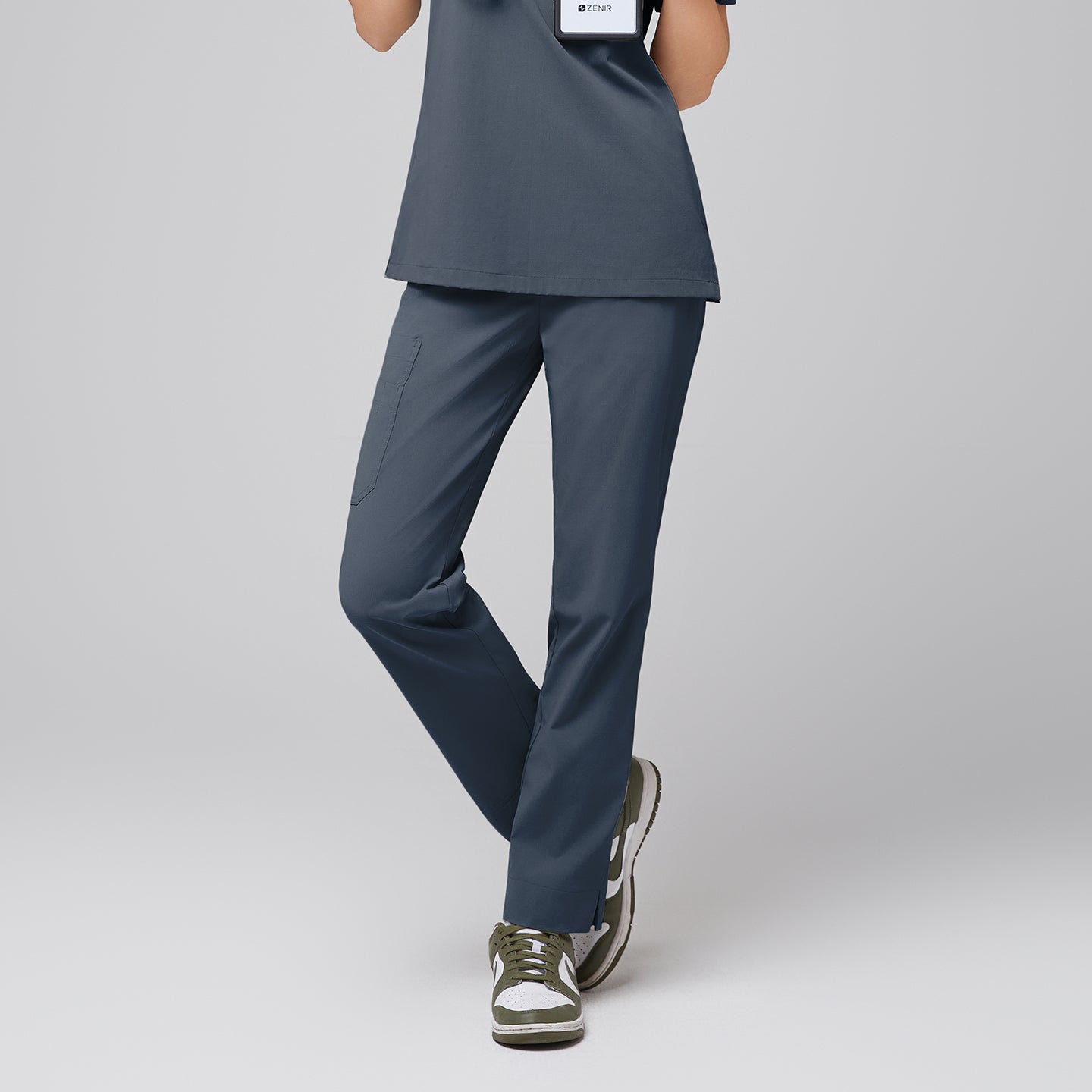 Image of Front view of Zenir Smoky Blue straight scrub pants with a split hem and functional side pocket, paired with green sneakers for a sleek look,Smoky Blue.