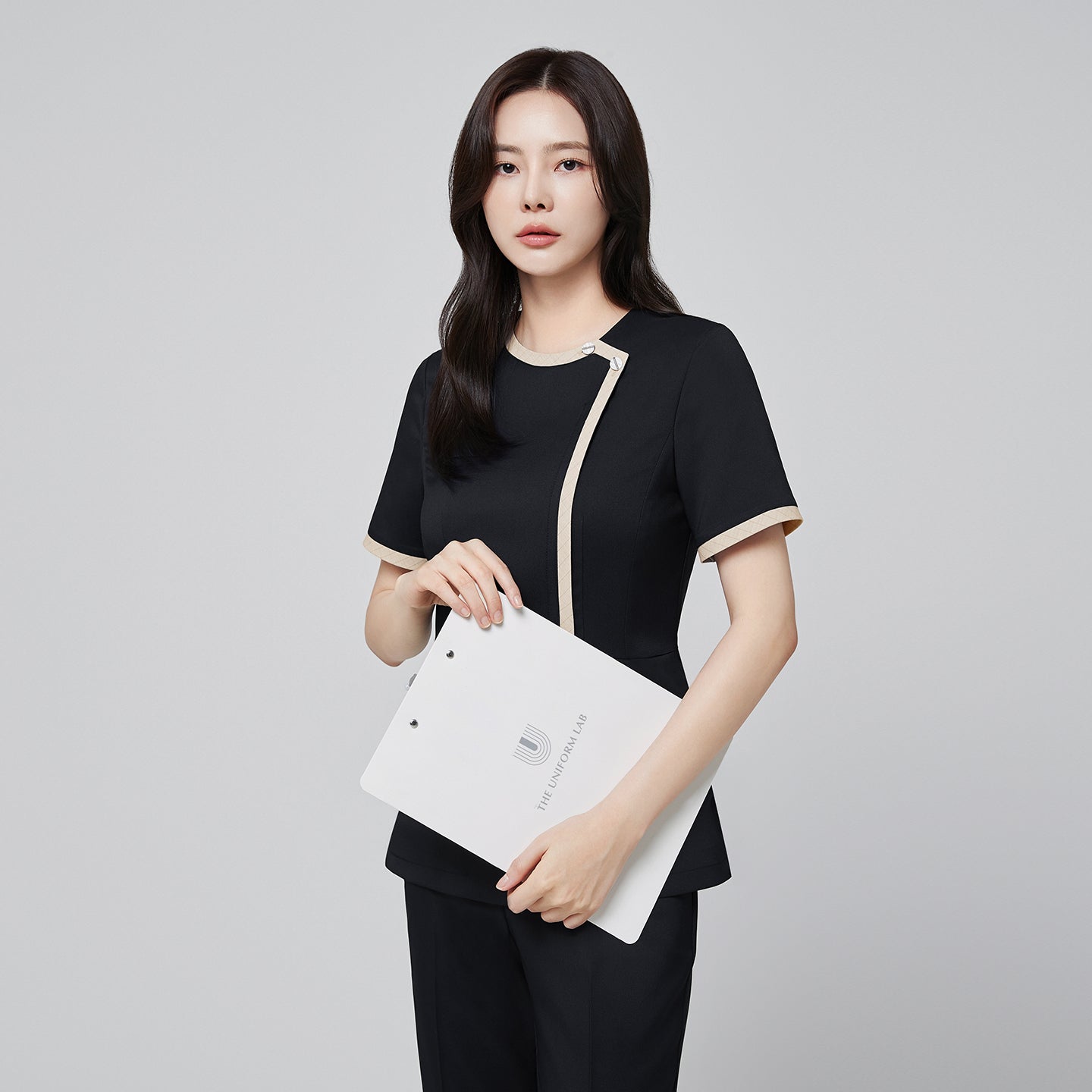 Front angle of TUL NS-175 Women’s Check Beige Round Collar Scrub Top in Stretch Black, highlighting a tailored waist and short sleeves.