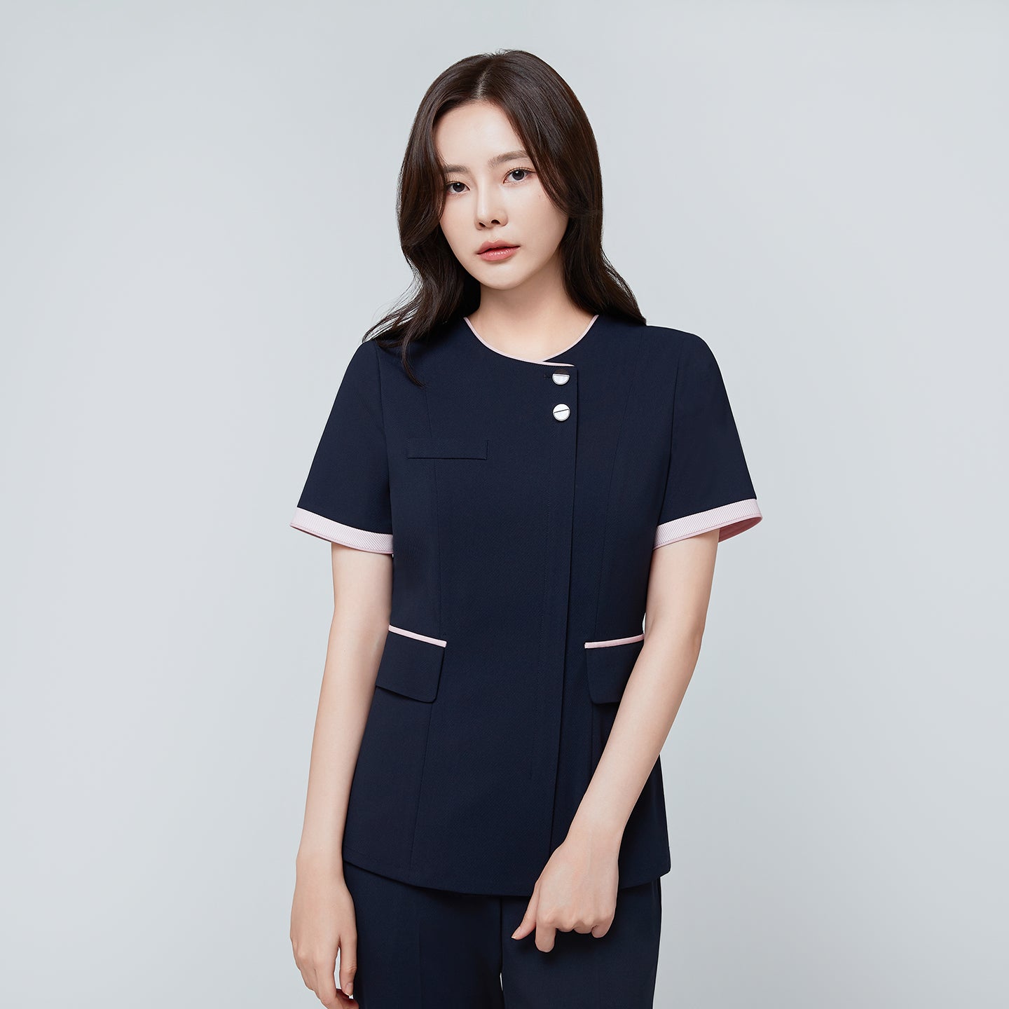 Front view of TUL NCS-04 Women’s Blush Edge Scrub Top in Stretch Navy, highlighting pink accent trim on the sleeves and collar.
