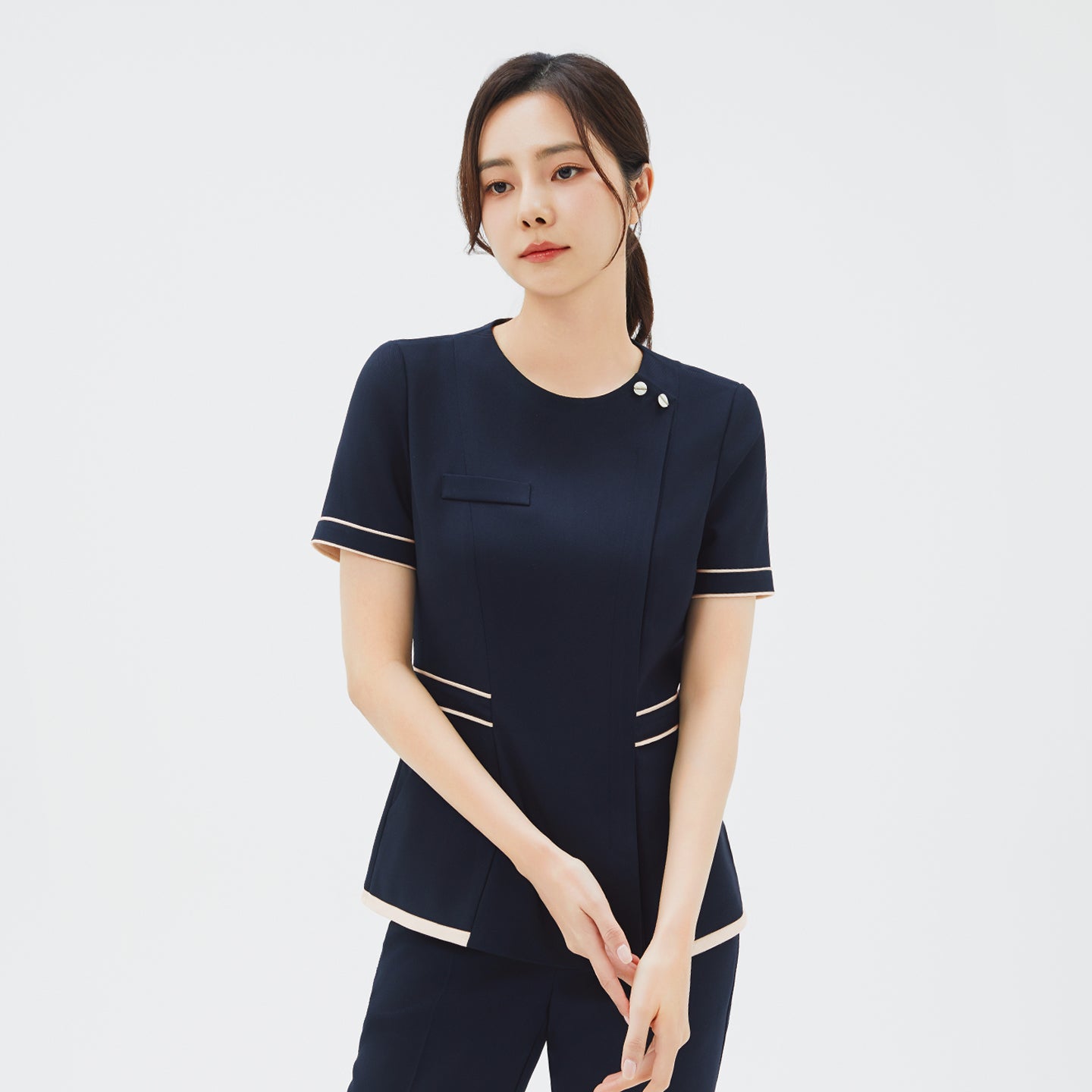 Image of Front angle of TUL NCS-07 Women's Ivory Dual Tone Scrub Top in Stretch Navy, featuring contrasting ivory trim at the sleeves and waist.