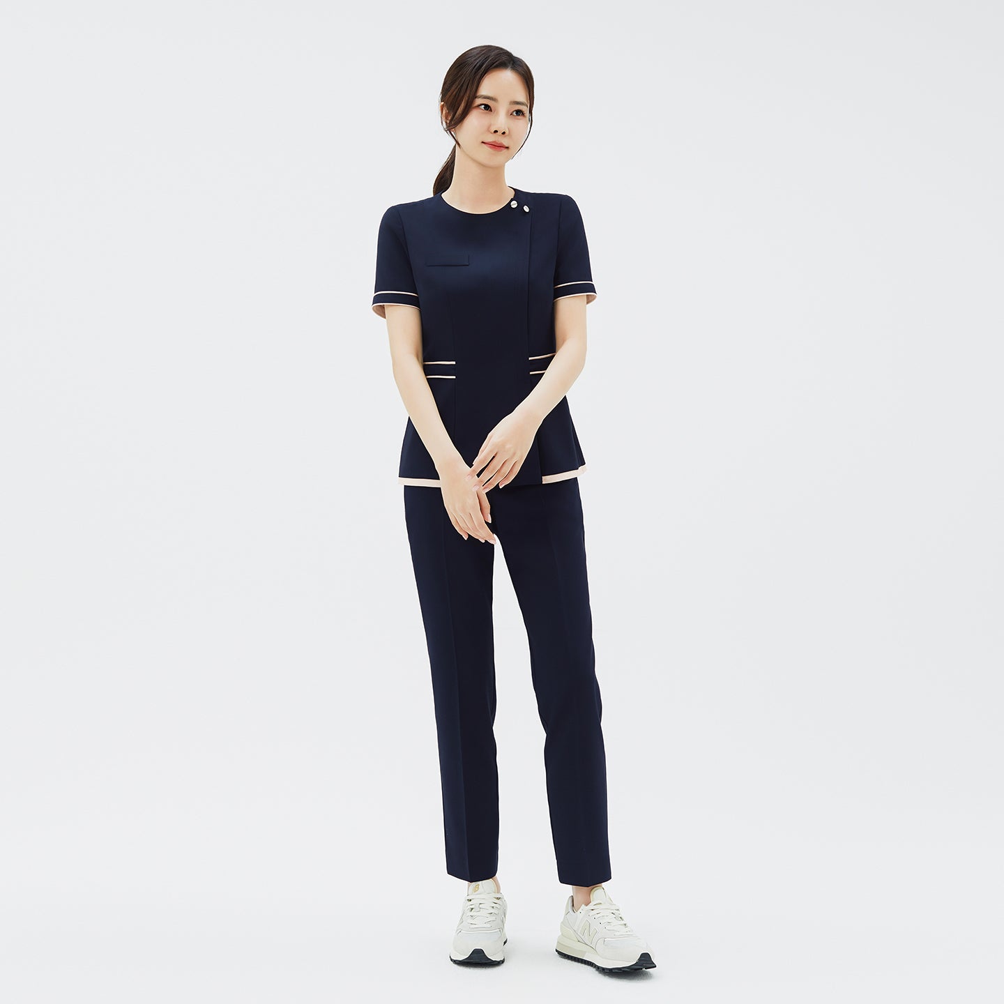 Full-length shot of TUL NCS-07 Ivory Dual Tone Scrub Top in Stretch Navy, paired with matching pants for a cohesive professional look.