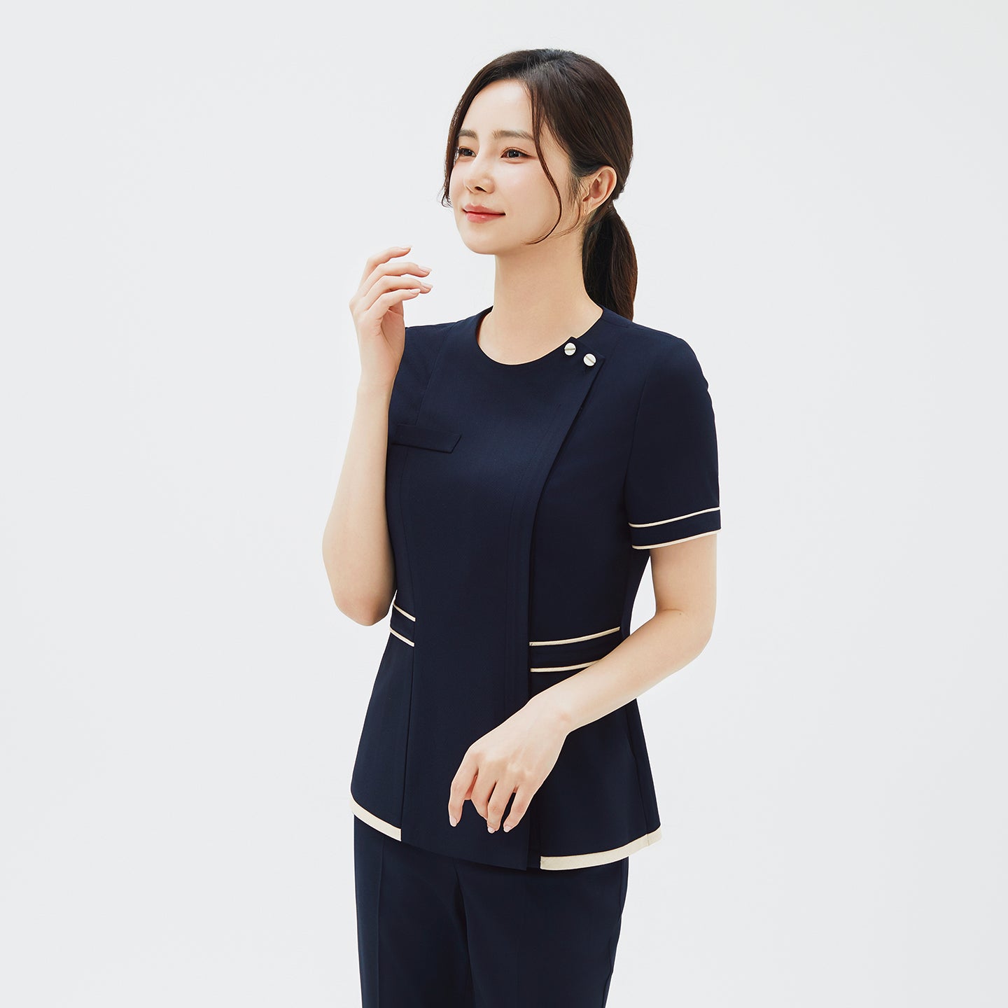 Image of Angled view of TUL NCS-07 Scrub Top, highlighting the dual tone design with ivory accents and stretch navy fabric details.