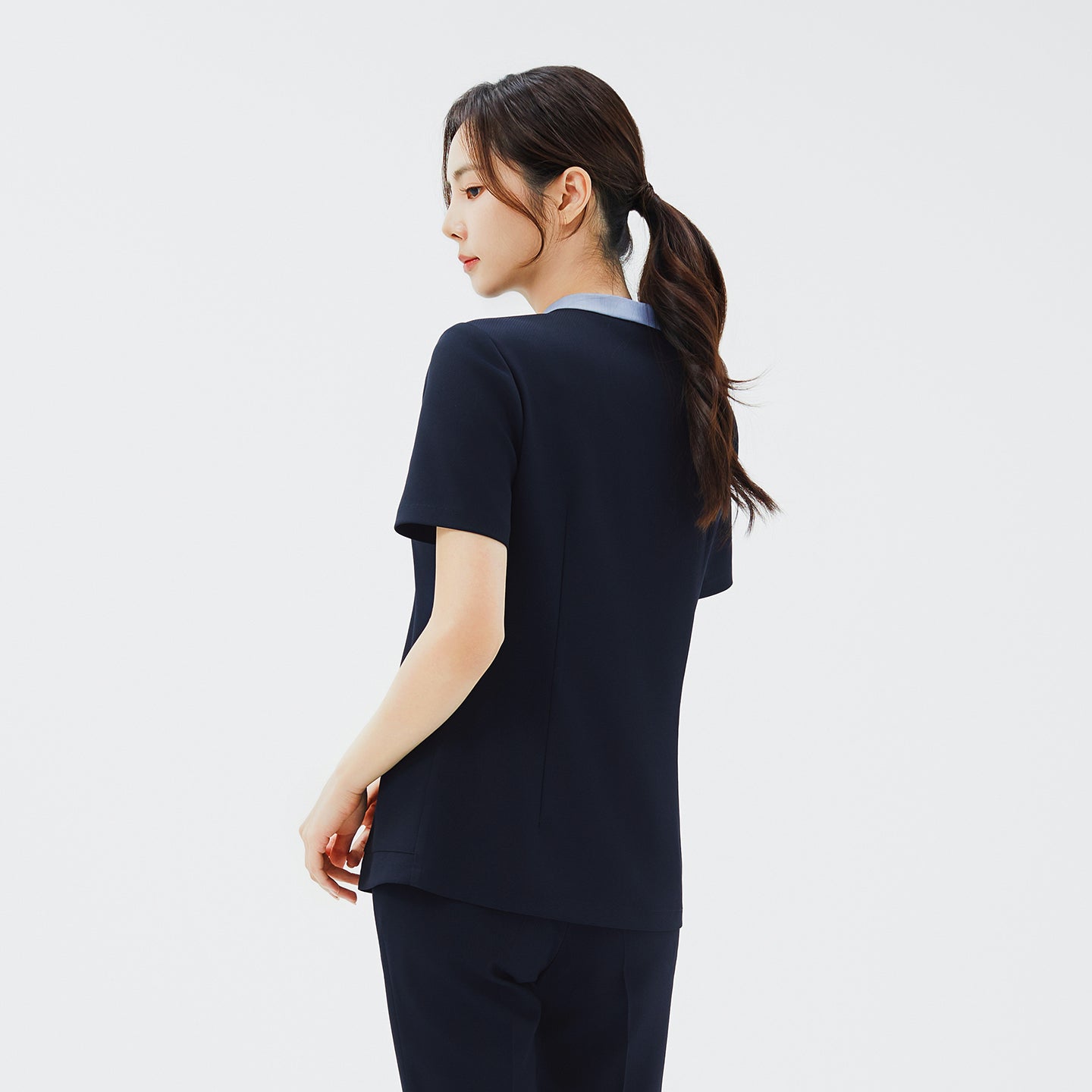 Back view of TUL NS-179 Stretch Navy scrub top, highlighting the comfortable short sleeves and subtle color-block collar from behind.