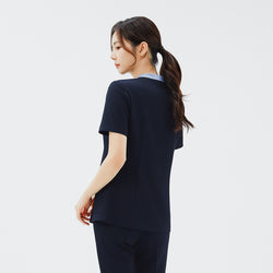 Image of Back view of TUL NS-179 Stretch Navy scrub top, highlighting the comfortable short sleeves and subtle color-block collar from behind.