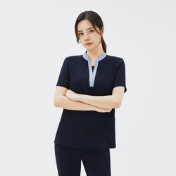 Image of Model wearing TUL NS-179 Women's V-Stretch Color Scrub Top in Stretch Navy, with arms crossed to emphasize a tailored fit and color-accented neckline.
