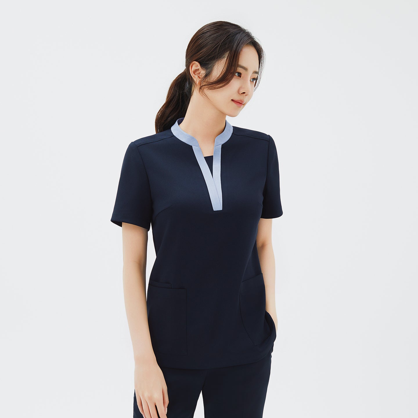 Image of Side angle of TUL NS-179 V-Stretch Color Scrub Top in Stretch Navy, showcasing a stylish V-neck trim and practical pockets.