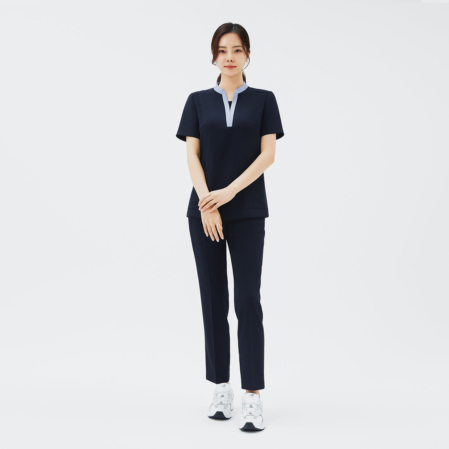 Image of Full-length shot of TUL Women's Style Pants in Stretch Navy, paired with a contrasting collar scrub top for a modern, professional look.