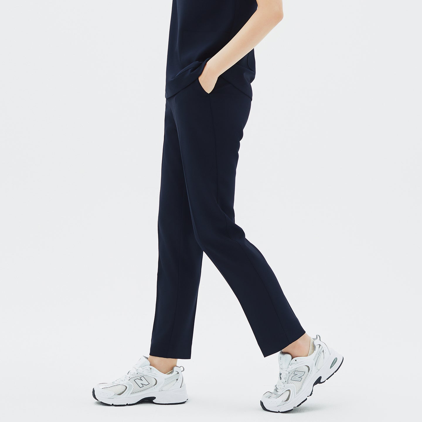 Model walking in TUL Women's Style Pants in Stretch Navy, emphasizing a comfortable, tapered fit and durable stretch material.