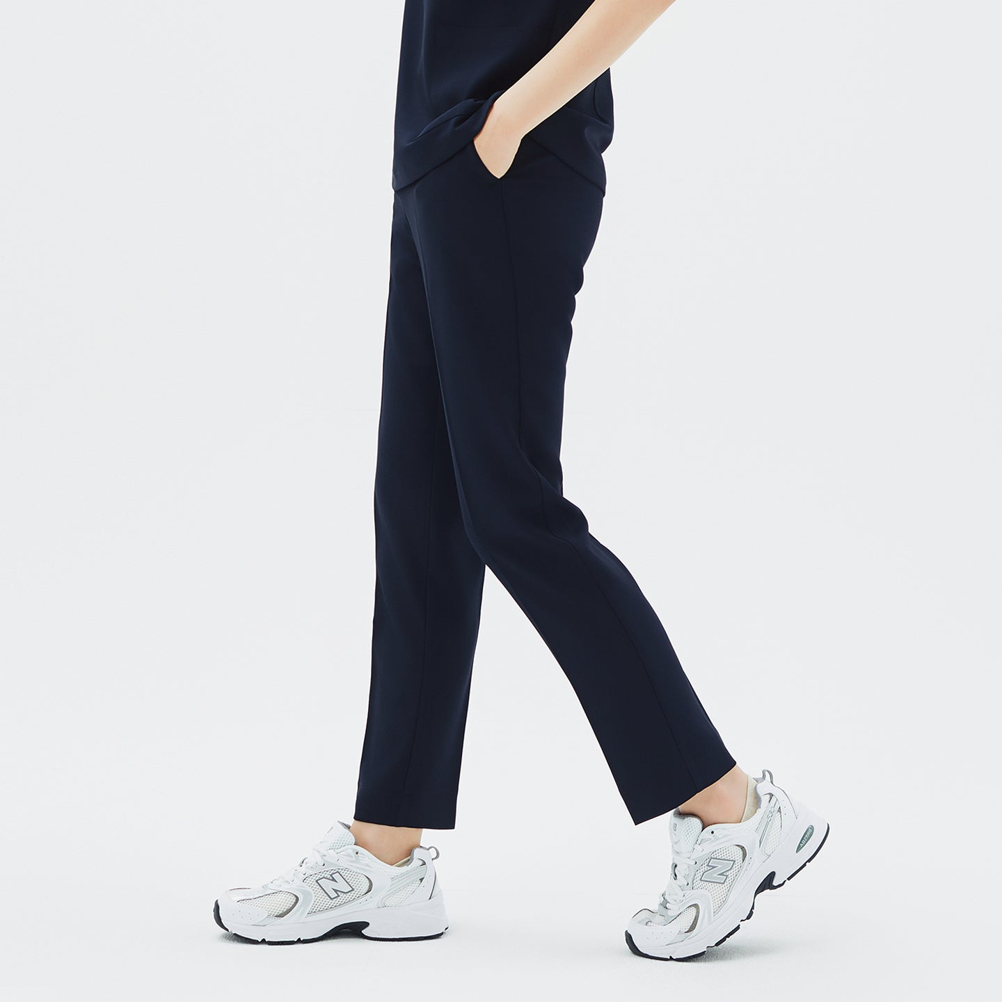 Image of Model walking in TUL Women's Style Pants in Stretch Navy, emphasizing a comfortable, tapered fit and durable stretch material.