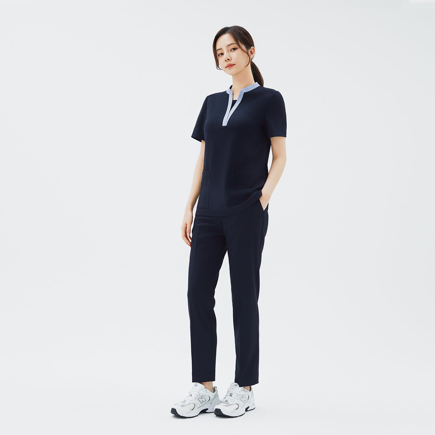 Image of Model wearing TUL Women's Style Pants in Stretch Navy, featuring a refined silhouette and practical pockets for healthcare professionals.