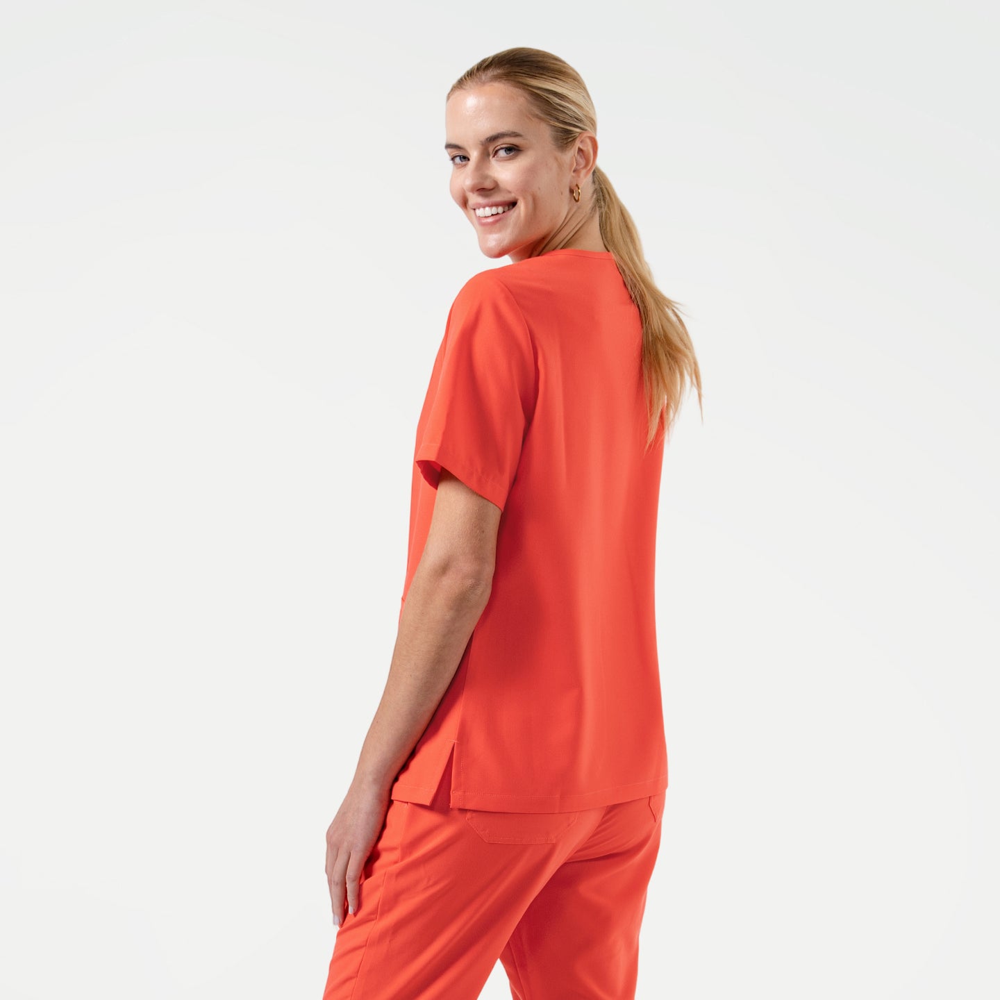 Image of Tiger Orange Double Pocket Scrub Top showcases a clean and minimal back profile with subtle side slits for ease of movement.
