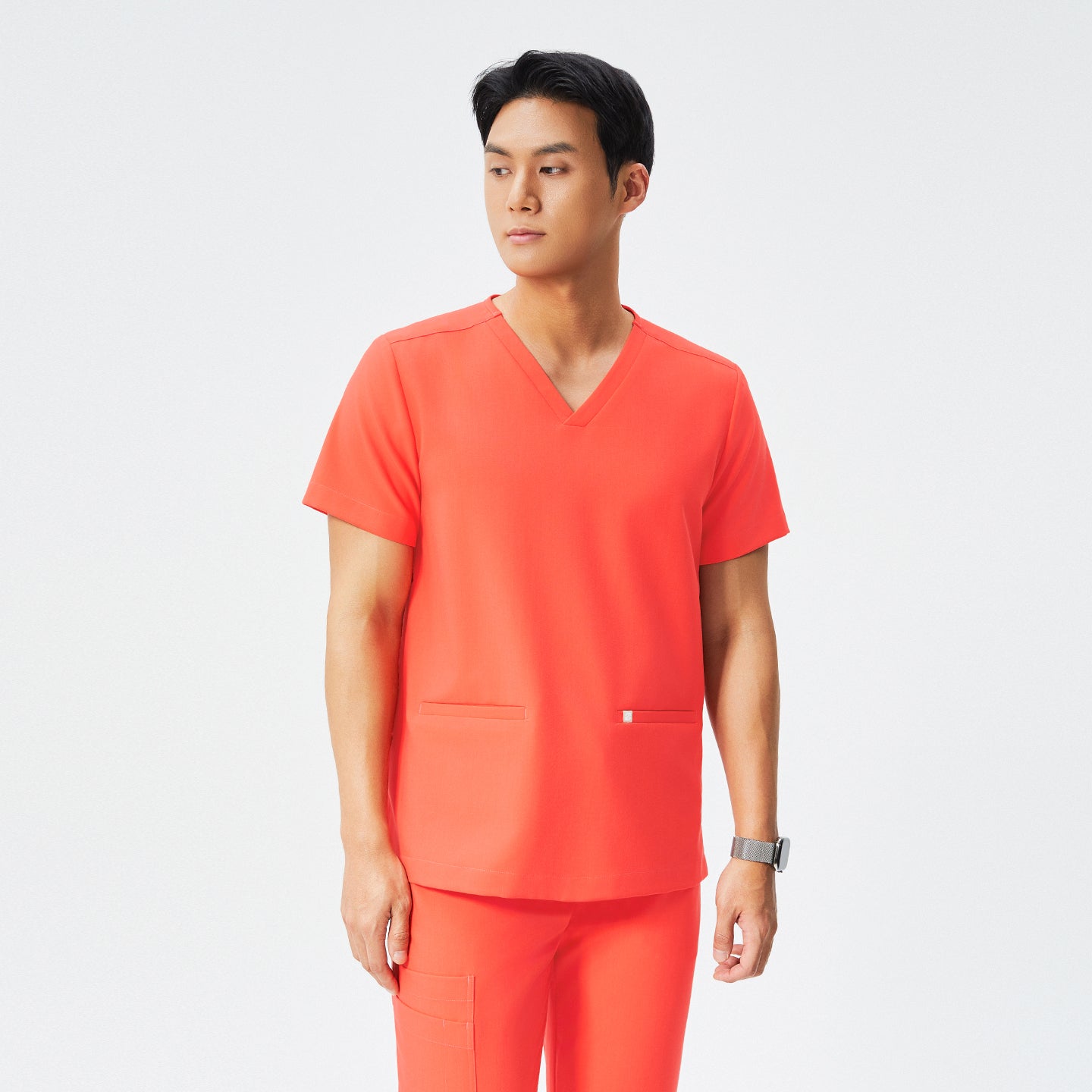 Image of Double-pocket V-neck top and tiger orange scrub set, man facing sideways, tiger orange