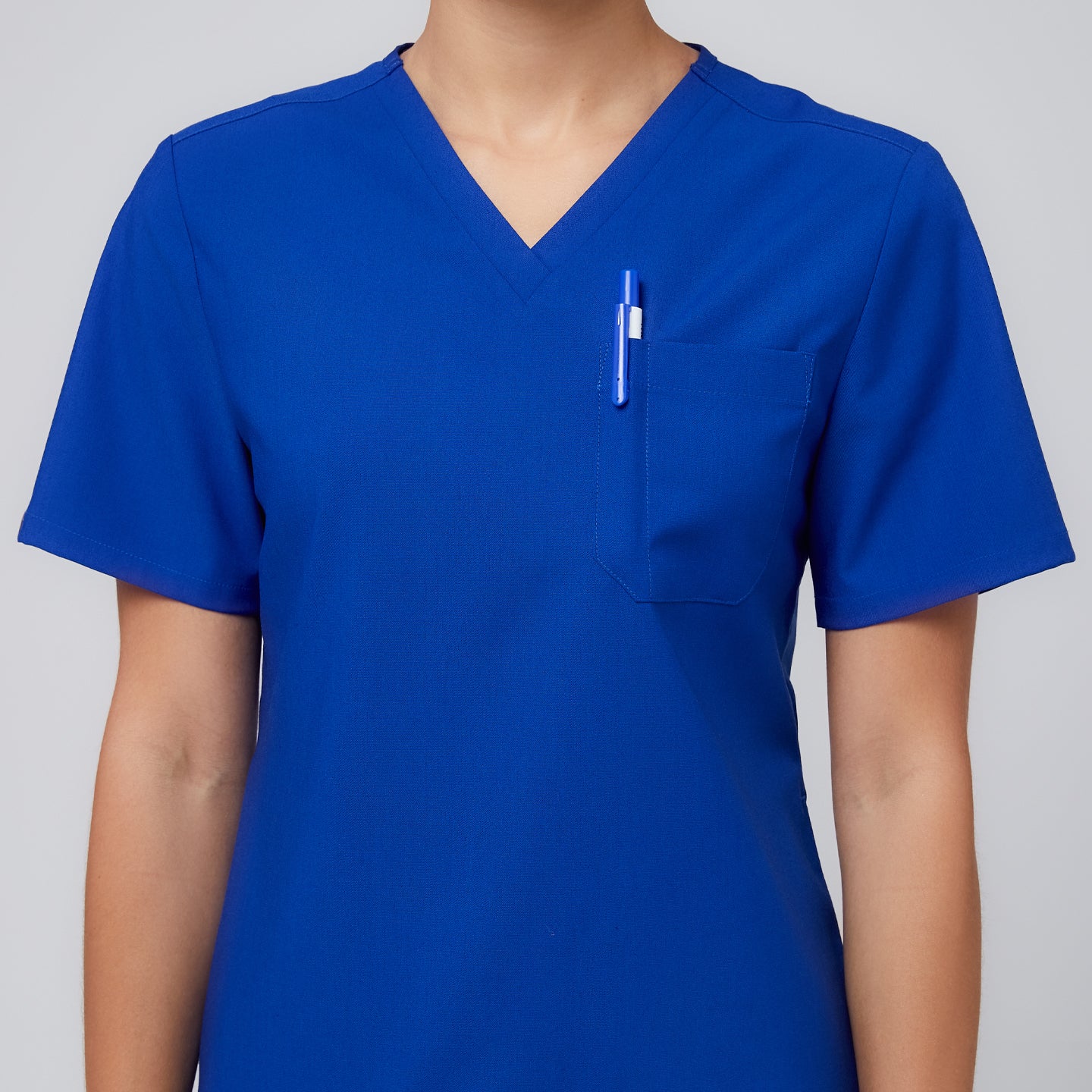 Image of Close-up of Zenir royal blue 3-pocket scrub top with a pen in the chest pocket,Royal Blue