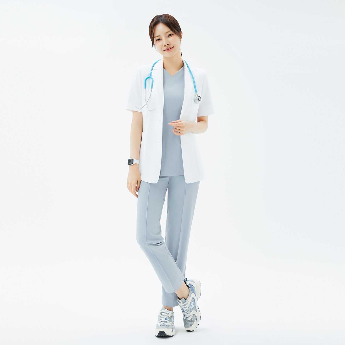 Full-length portrait of the TUL Women’s LCW-15 Lightweight Short Sleeve Lab Coat – White worn with a stethoscope around the neck.