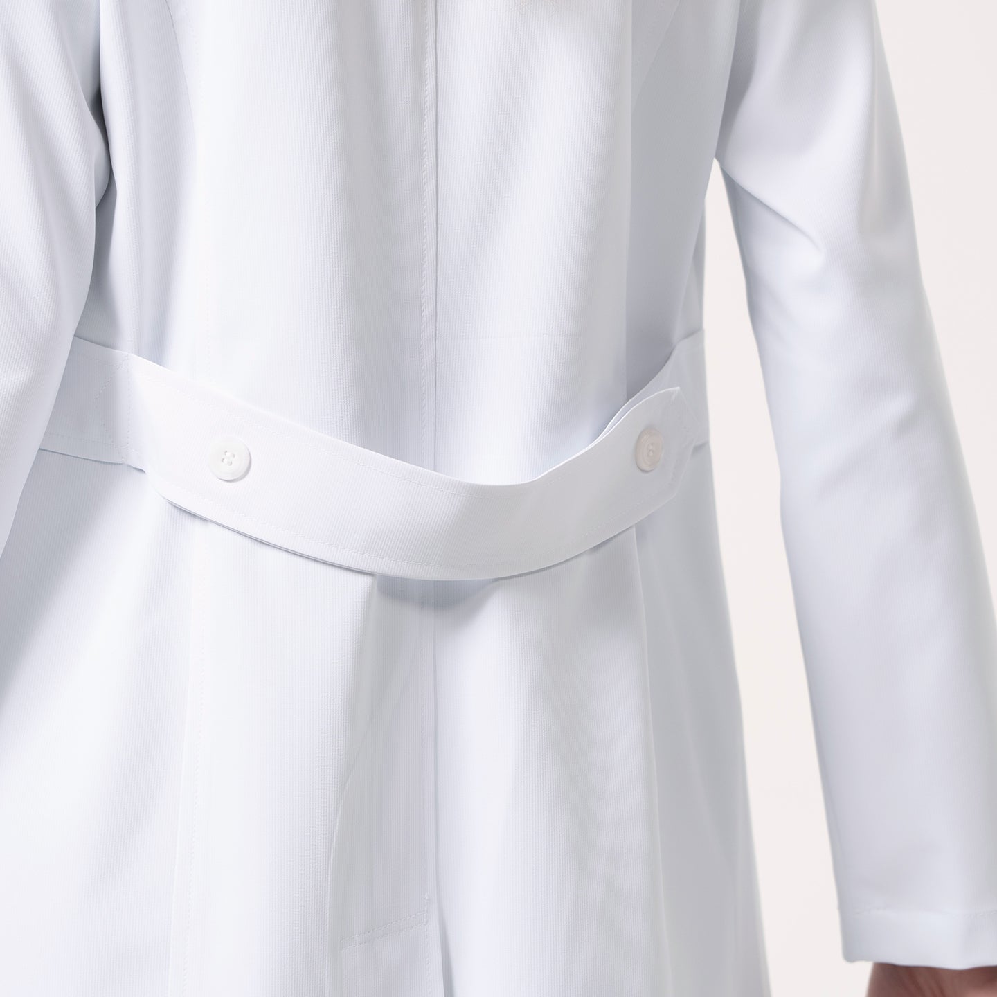 Image of Close-up of the back of the Women’s Long Lab Coat LCW-04 in white, highlighting the buttoned belt detail at the waist.