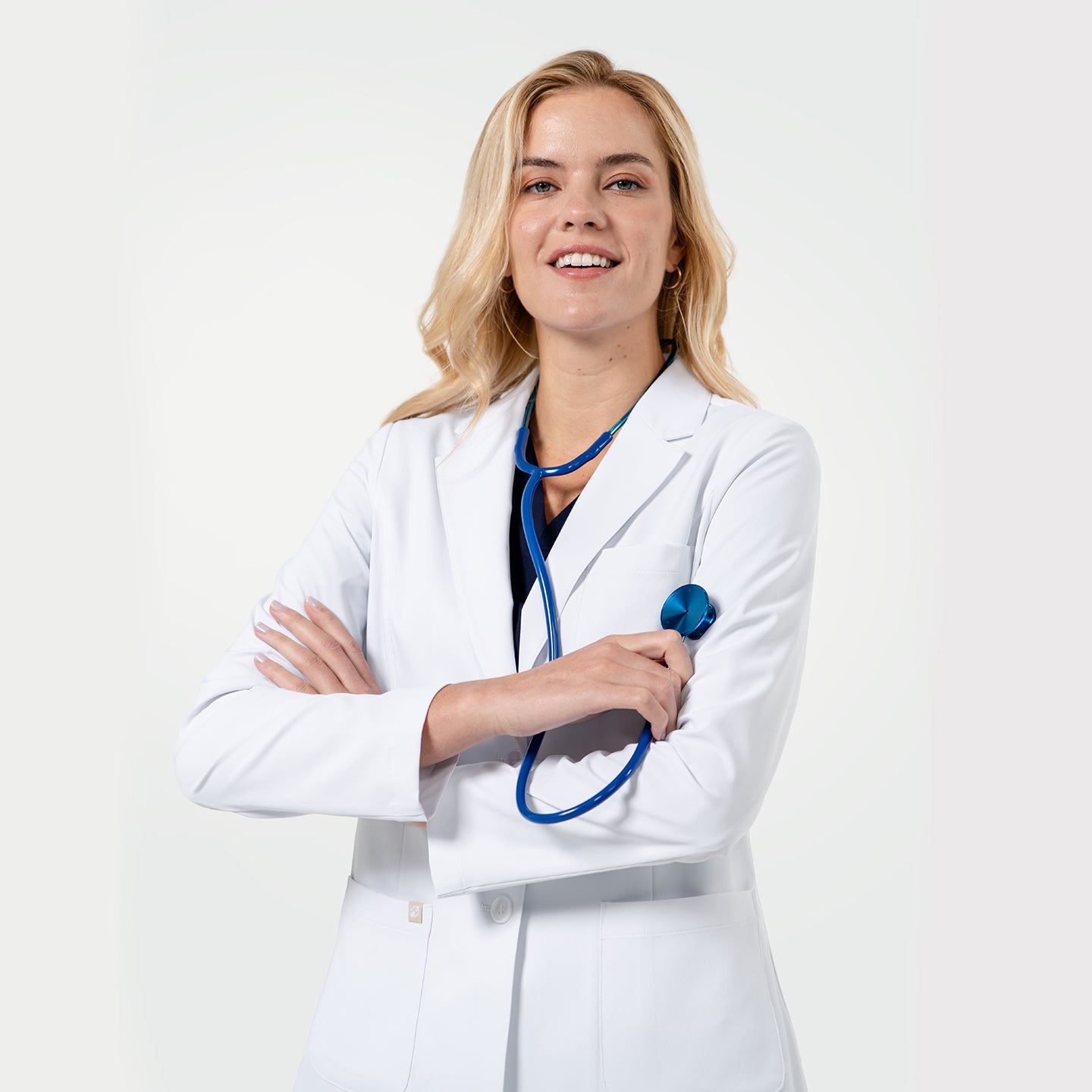 Image of A smiling doctor wearing a white lab coat and stethoscope, standing on a light gray background in a professional mood.