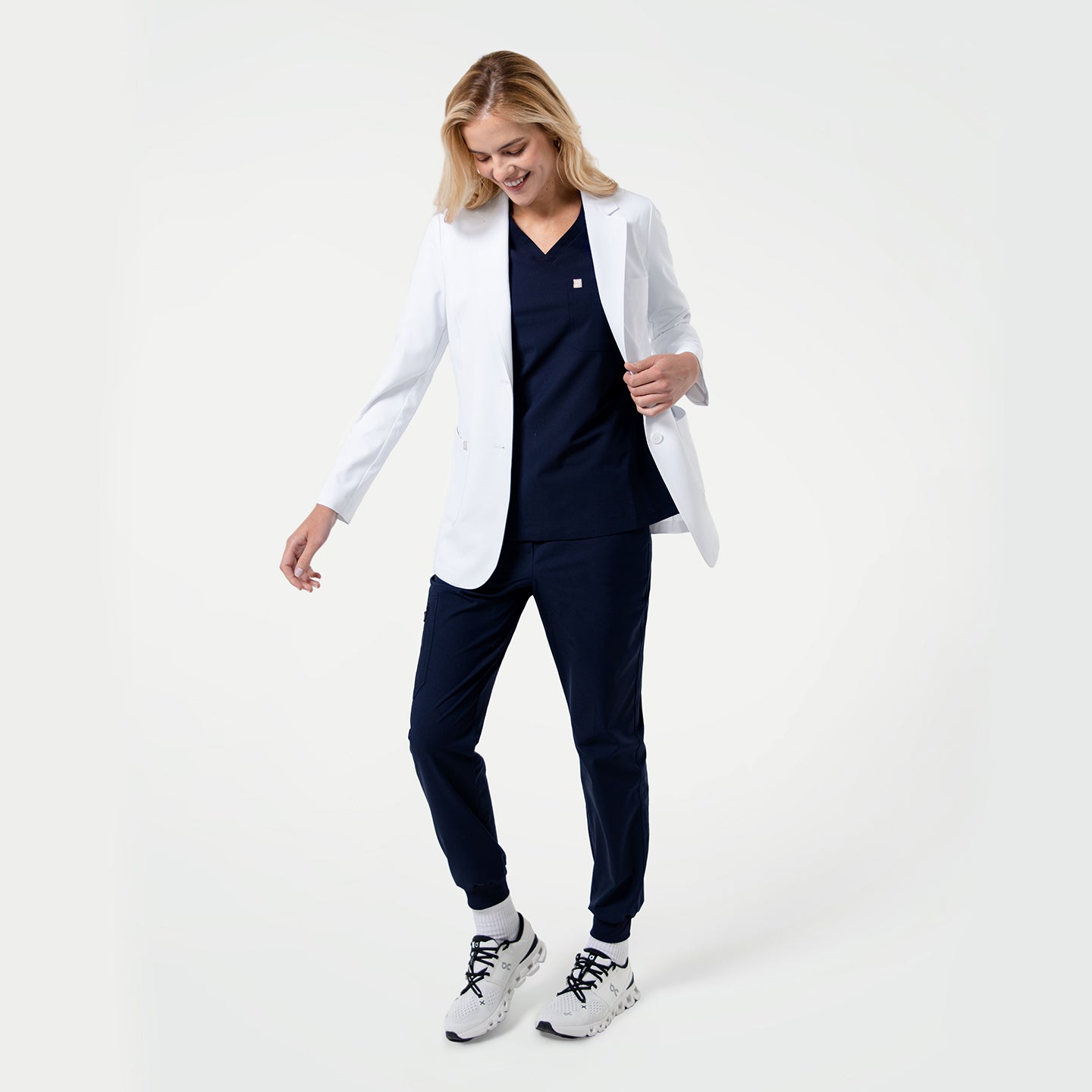 Image of Women wearing a LCW-02 short white lab coat over a navy outfit on a white background