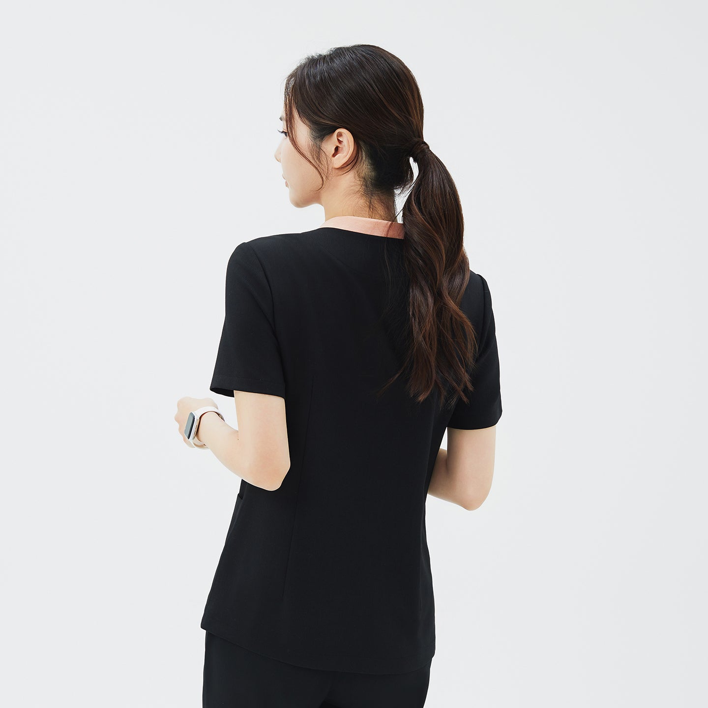 Back view of TUL NS-178 Women's V-Stretch Color Scrub Top in YT Black, emphasizing structured seams, a crisp neckline with subtle color detail, and a comfortable, professional silhouette.