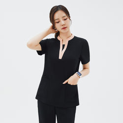 Image of Model wearing TUL NS-178 Women's V-Stretch Color Scrub Top in YT Black, paired with matching scrub bottoms, demonstrating a sleek, professional look and versatile style suitable for healthcare settings.