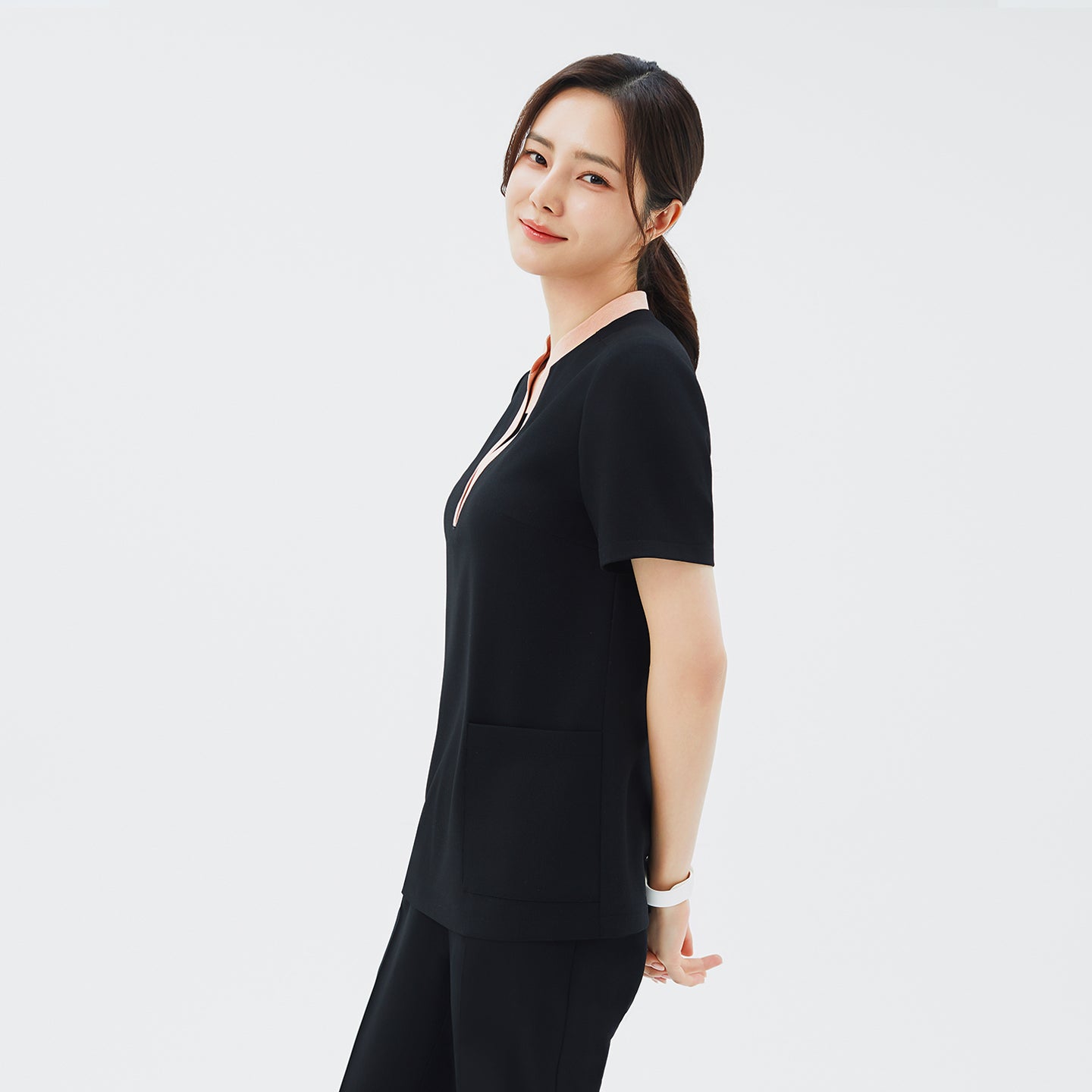 Image of Side angle of TUL NS-178 Women's V-Stretch Color Scrub Top in YT Black, highlighting the tailored fit, draped sleeve edges, and the modern stretch fabric design.
