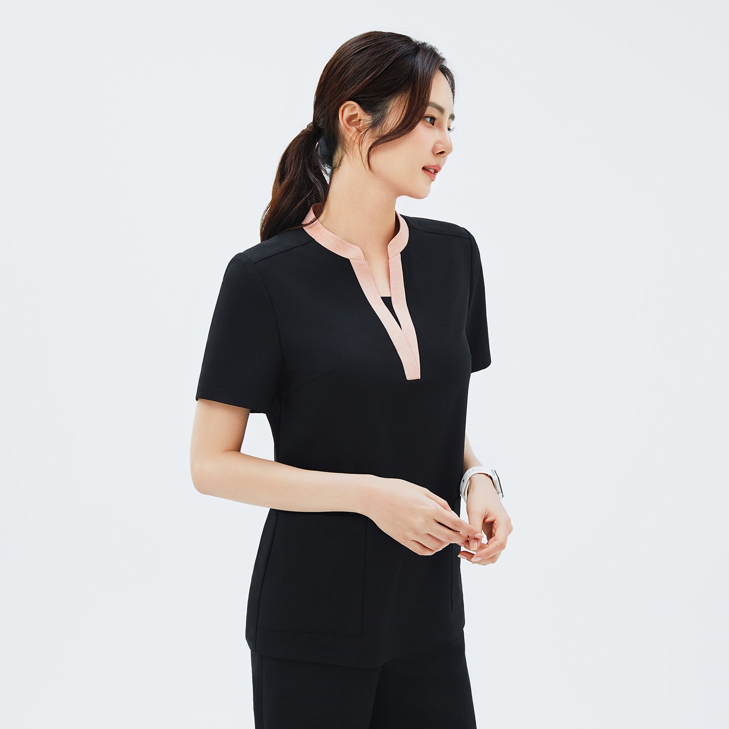 Side angle of TUL NS-178 Women's V-Stretch Color Scrub Top in YT Black, highlighting the tailored fit, draped sleeve edges, and the modern stretch fabric design.
