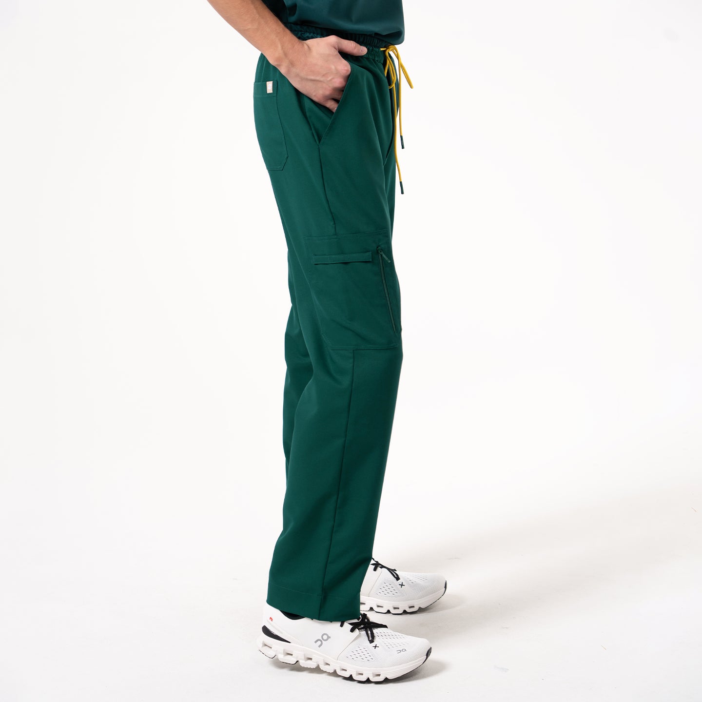 Image of One hand rests in the pocket while the person stands straight in Pine Green zipper pocket scrub pants.